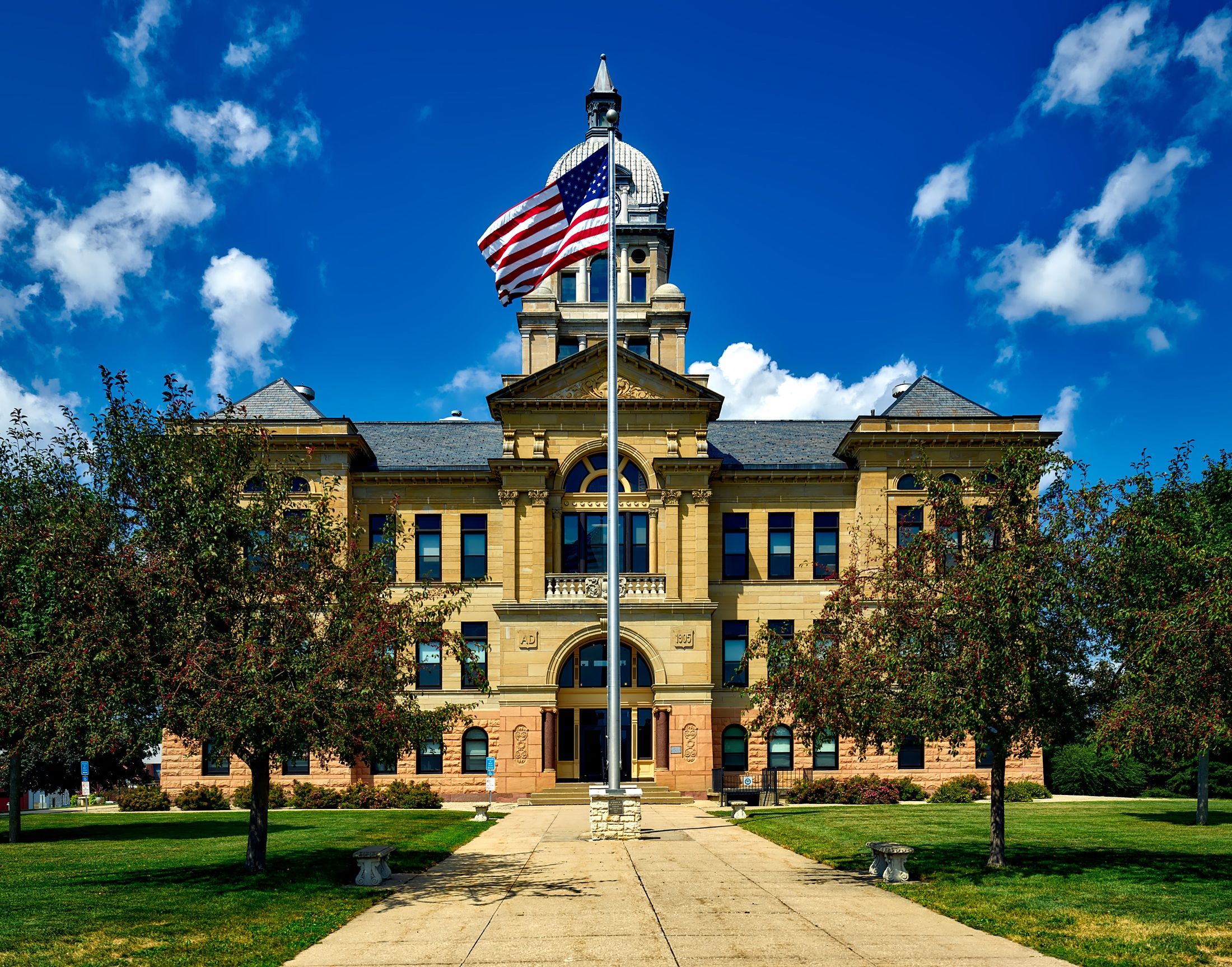 Grand courthouse building with an American flag against a blue sky
