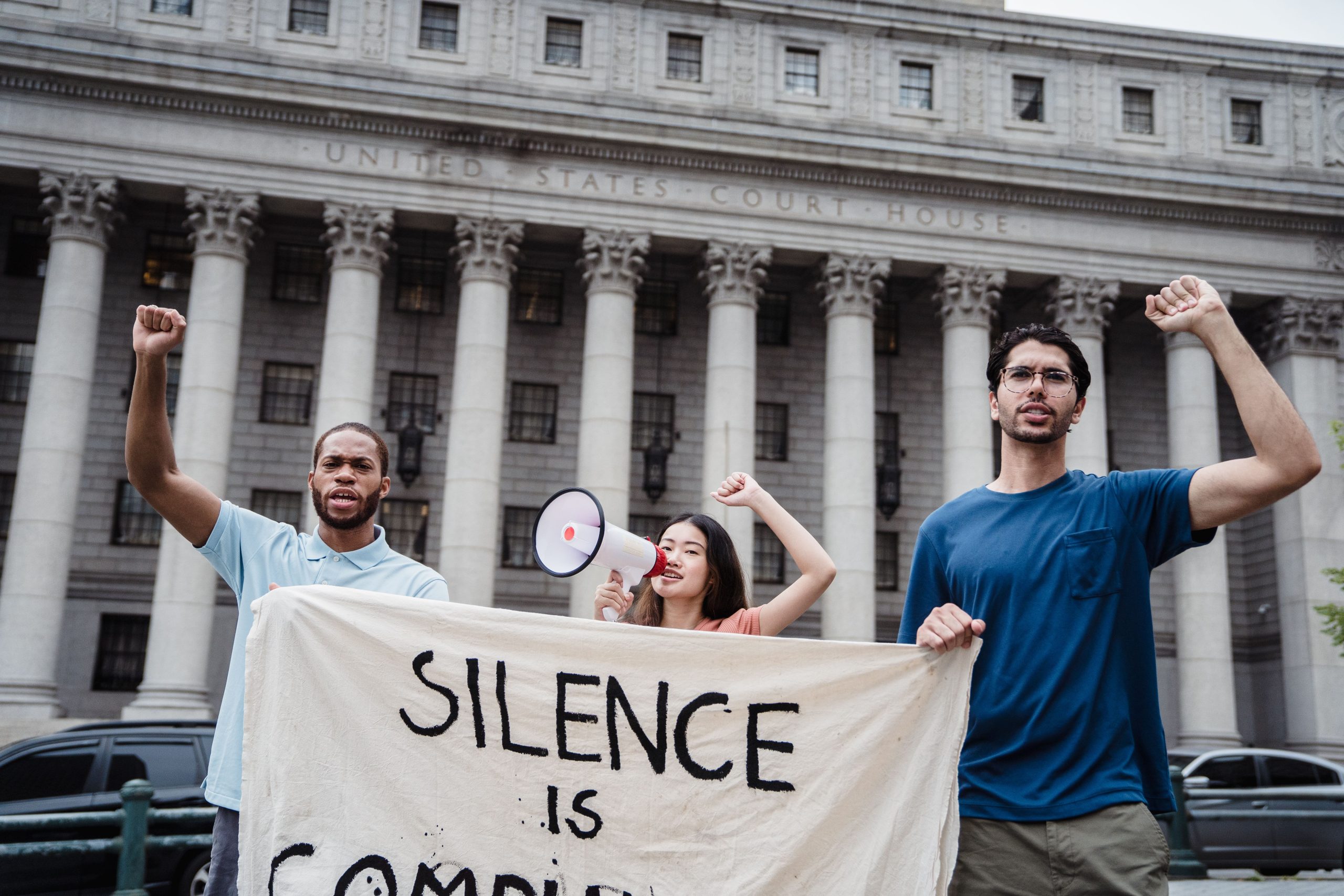 Group of diverse people holding a banner outside a US courthouse, representing a class action lawsuit