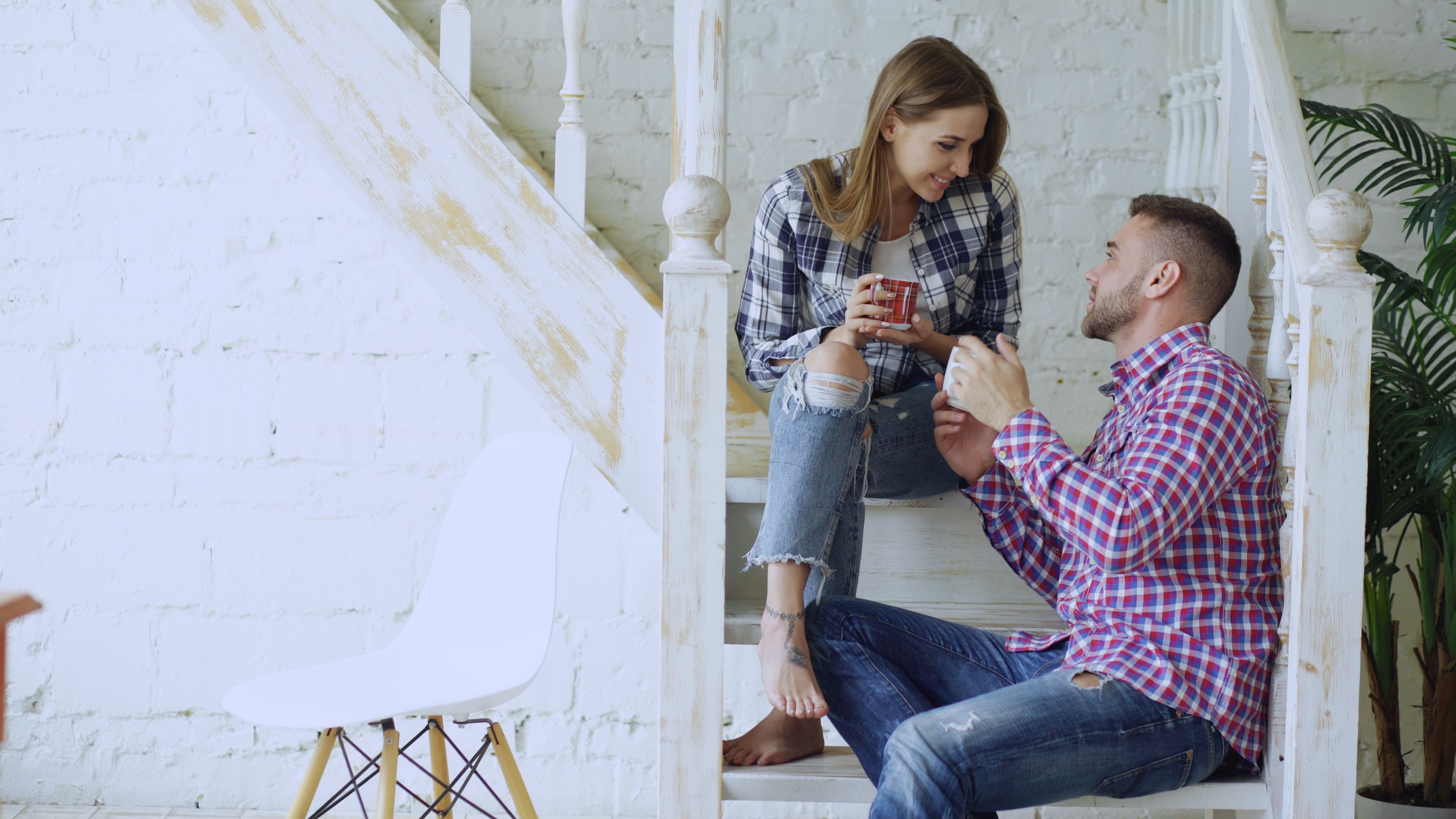 Young couple relaxing together with coffee indoors, representing casual intimacy and emotional companionship.