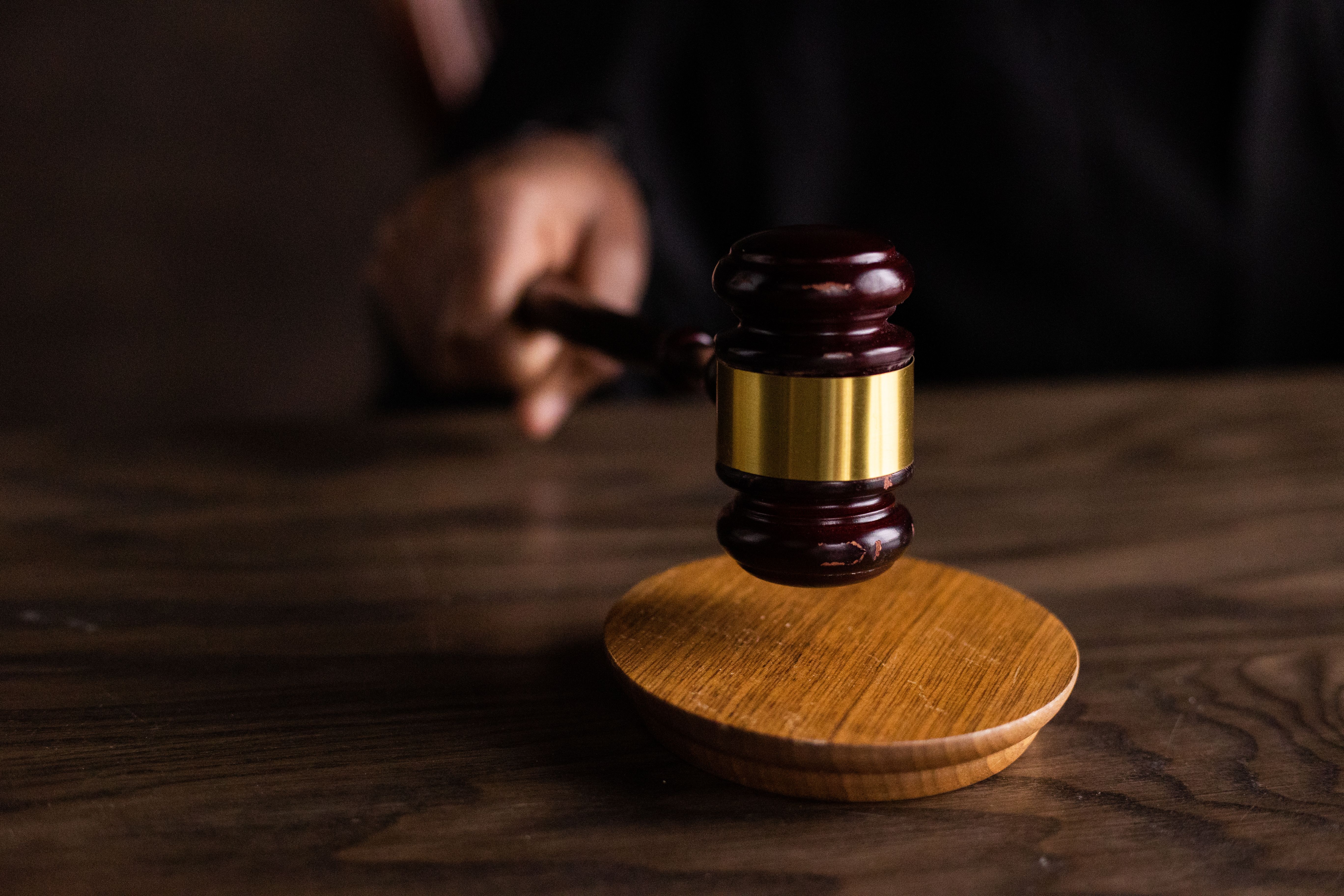 A judge's gavel striking a sound block in a courtroom symbolizing legal authority