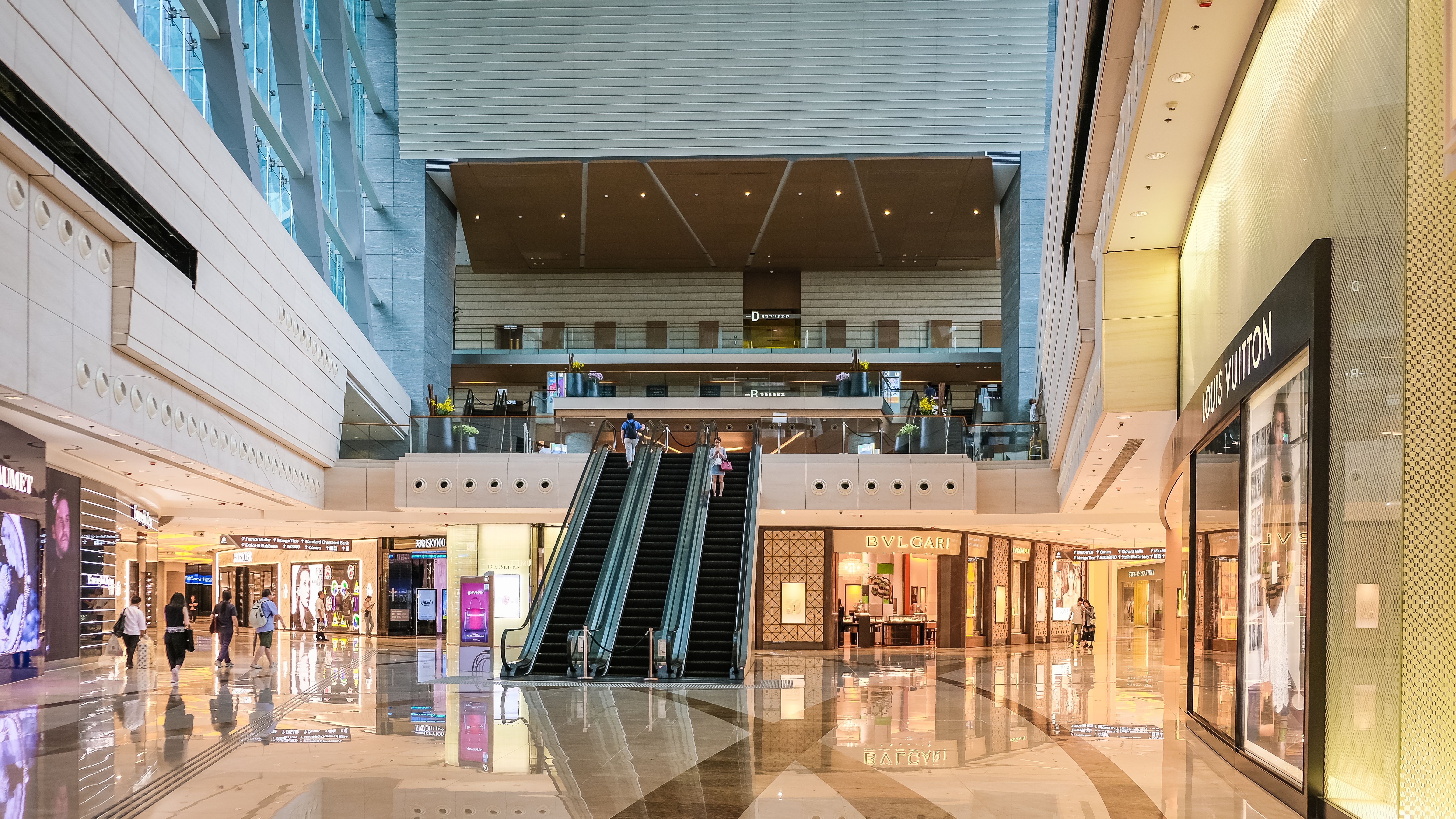 Modern Hong Kong shopping mall interior with luxury stores, representing where to shop for lab-grown diamonds in Hong Kong.
