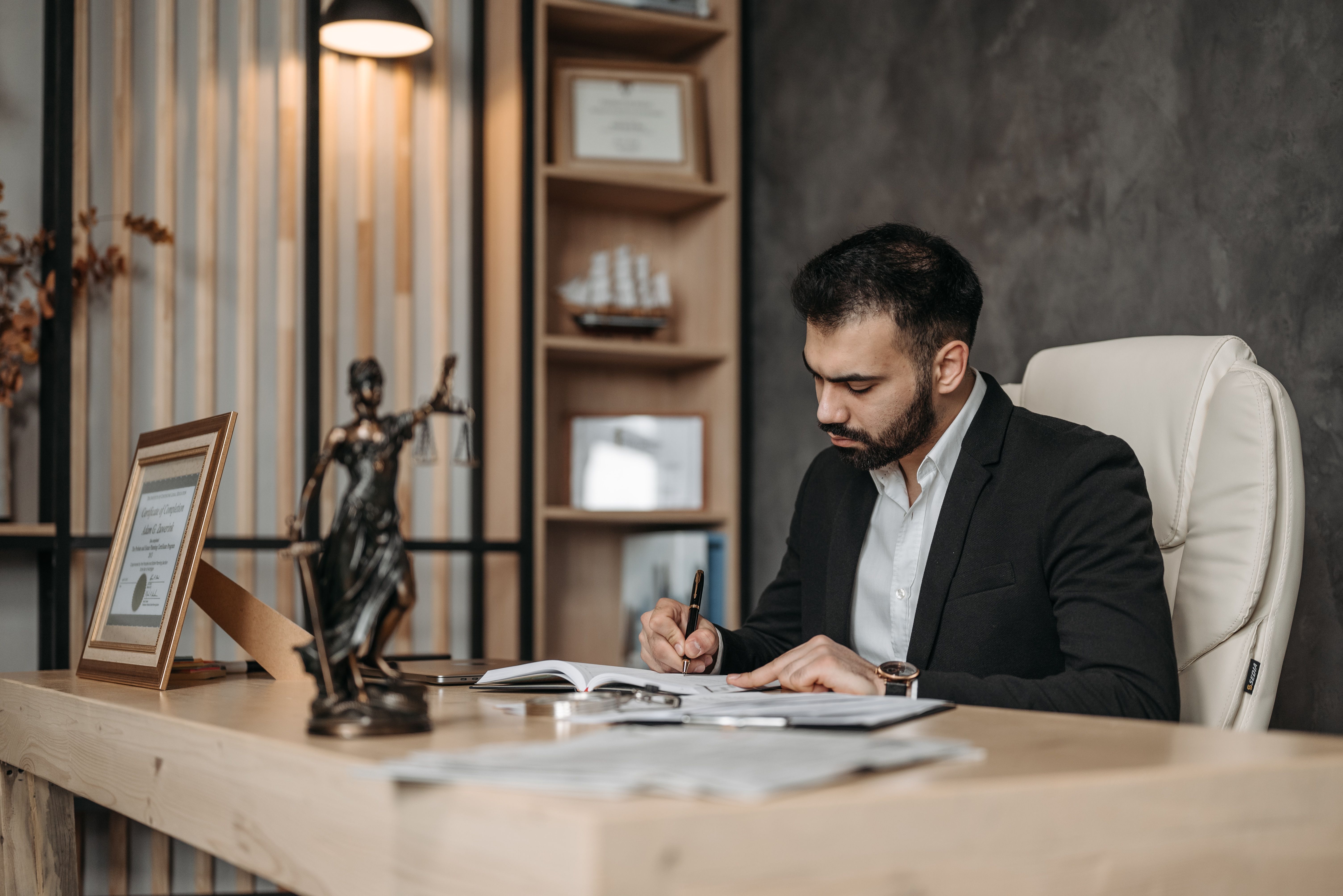 Focused lawyer in an office reviewing legal documents at a desk