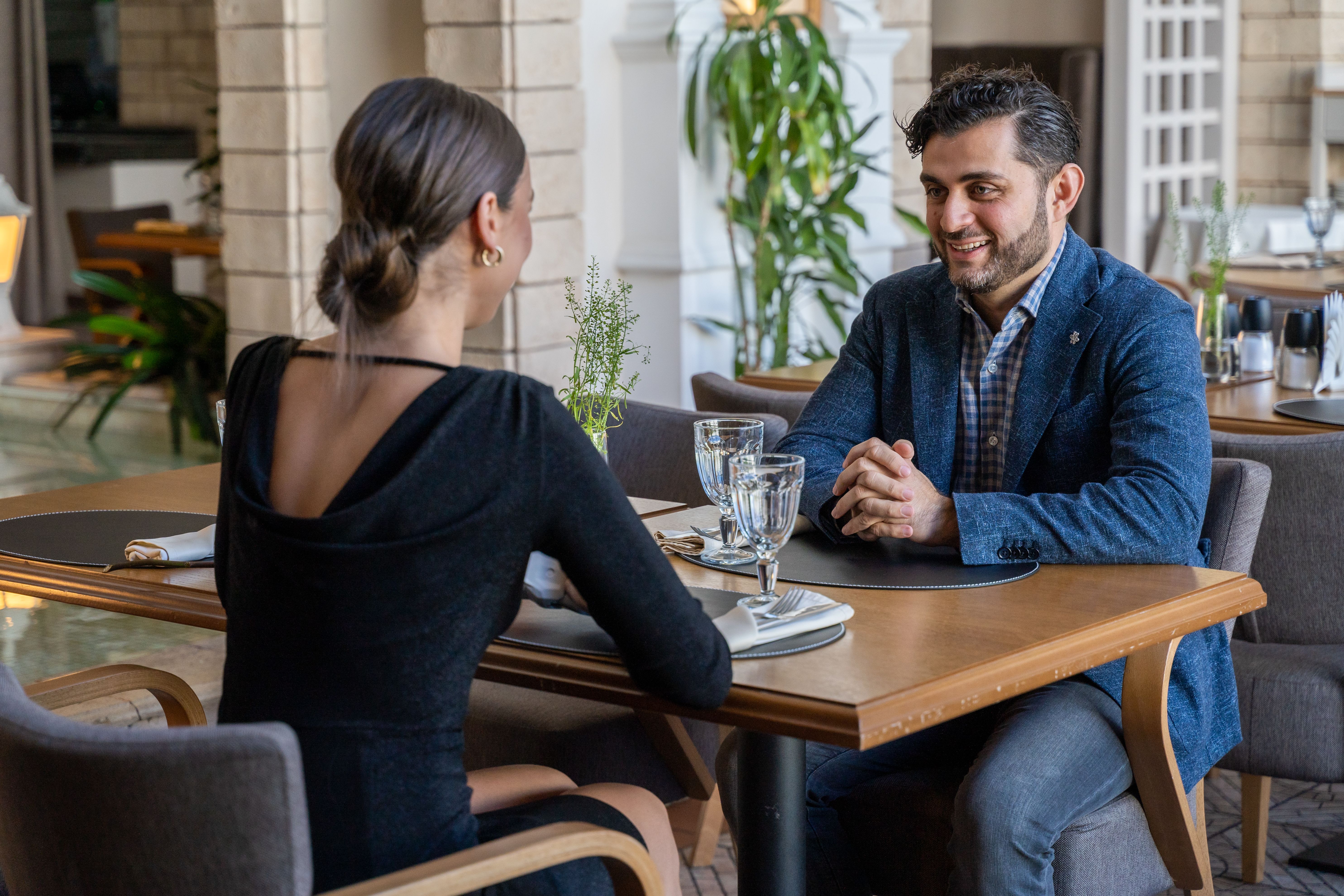 Couple sharing an intimate dinner at a stylish cafe, illustrating the social rituals of modern dating.